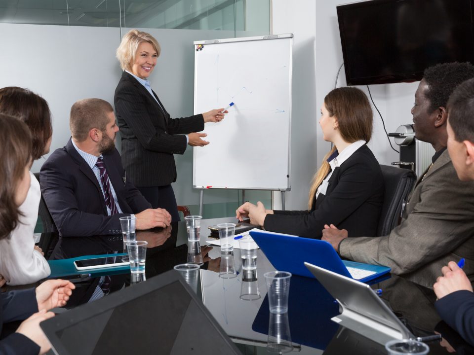 A woman in business attire is giving a presentation.